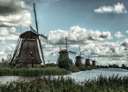 windmills near the lake under the cloudy sky