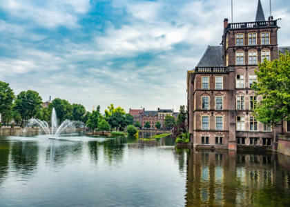 river with fountain, trees, and buildings in Amsterdam