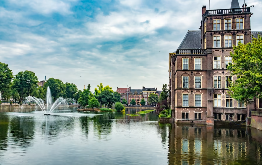 river with fountain, trees, and buildings in Amsterdam